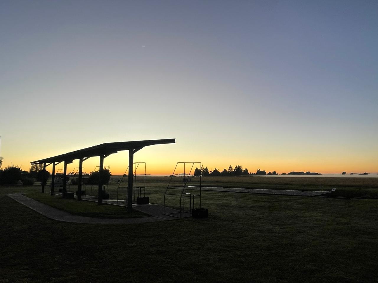 Sunrise silhouettes across the shooting stands