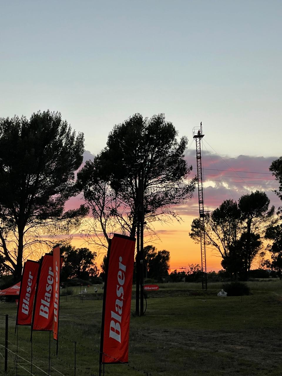 Blaser flags against a colourful sunset sky