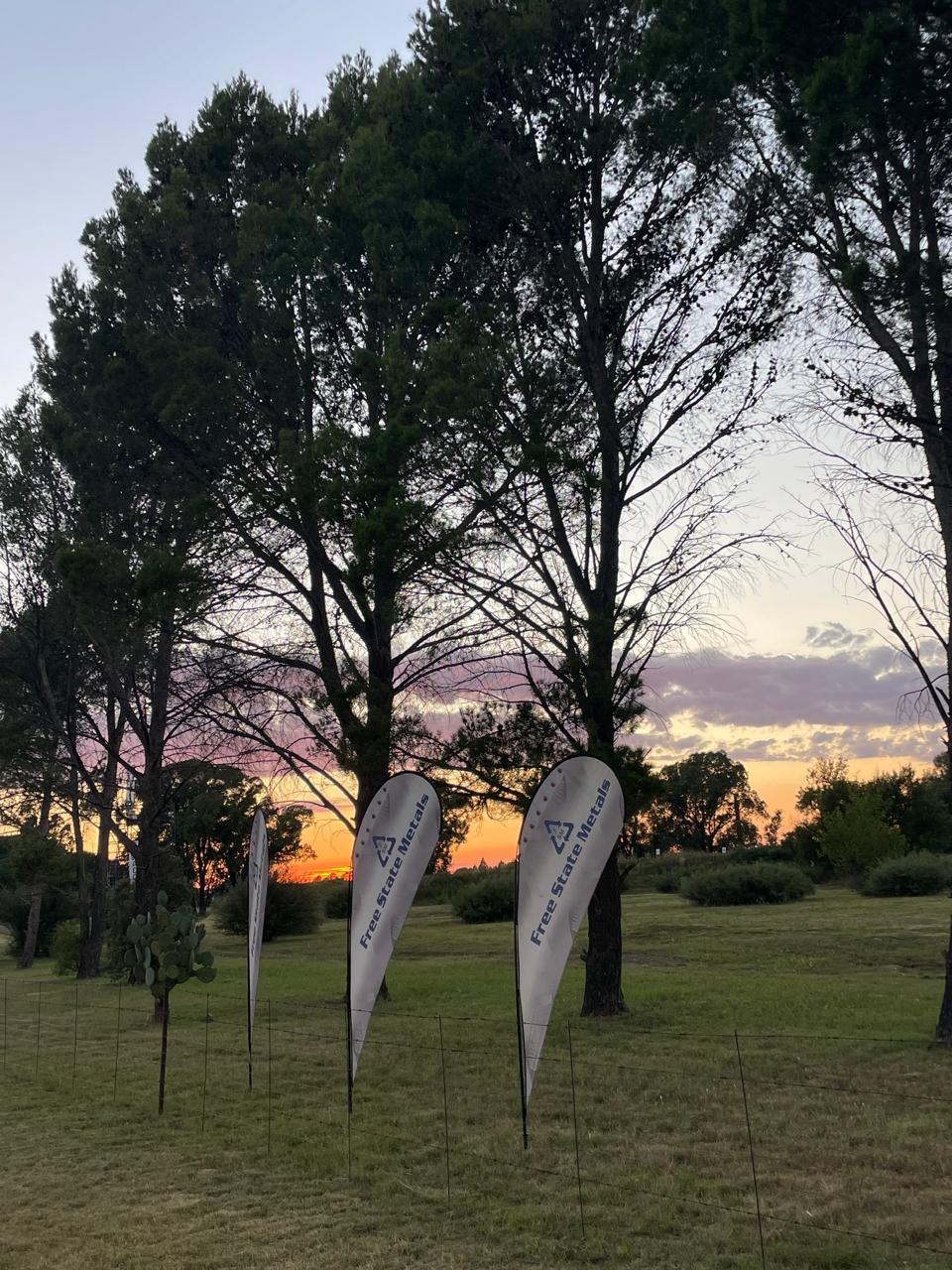 Free State Metals teardrop flags at sunset
